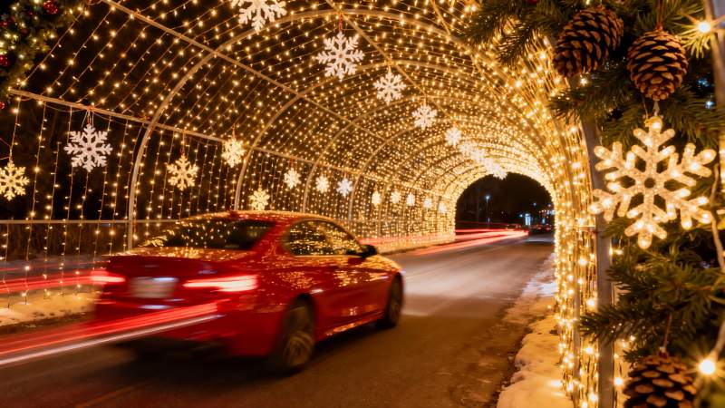 红色轿车驶过圣诞灯光隧道图片