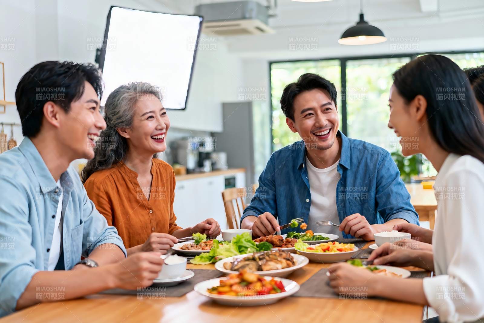 四人围桌用餐欢笑场景图片