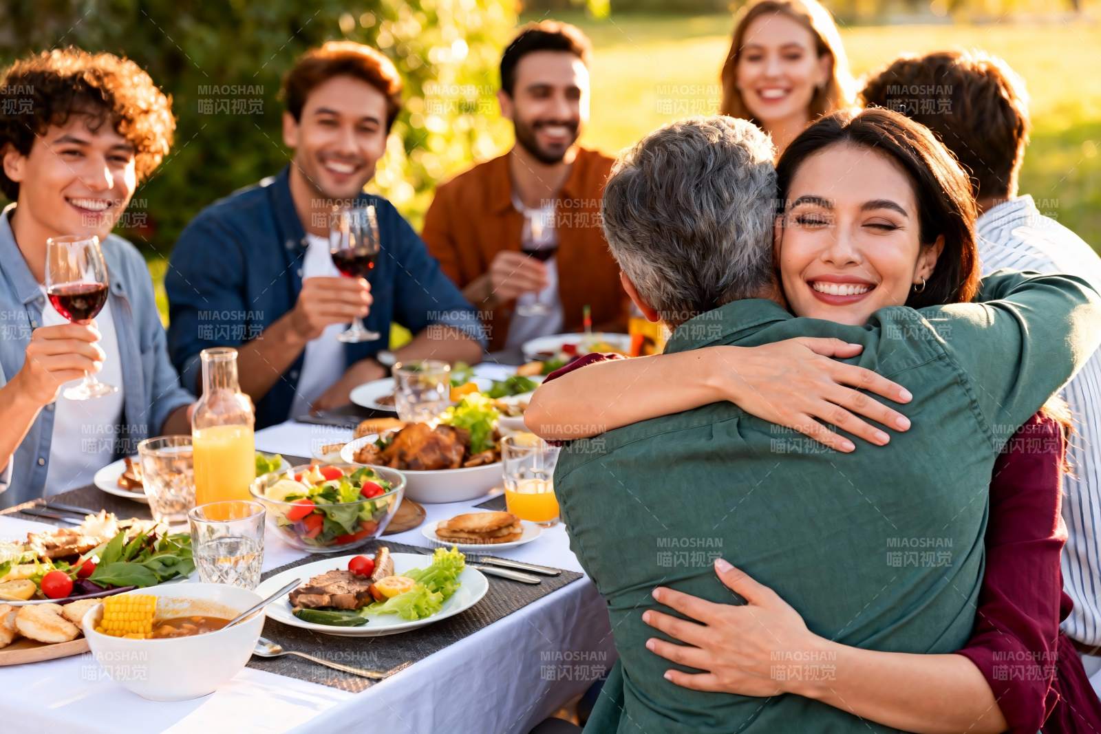 户外聚餐拥抱温馨场景图片