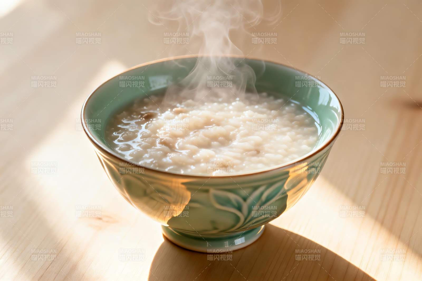 热气腾腾的米粥盛在青花瓷碗中图片