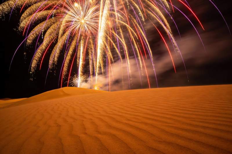 沙漠夜空烟花绽放绚丽景象图片