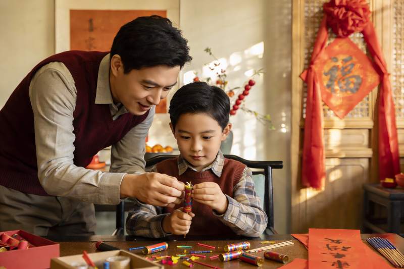 父子室内制作鞭炮准备节日图片