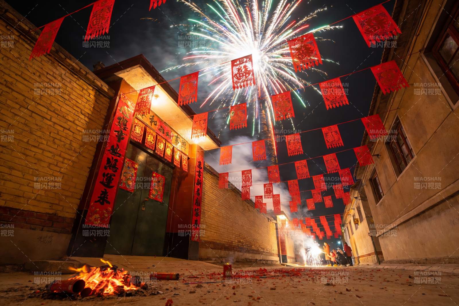 夜空烟花映照古巷喜庆场景图片