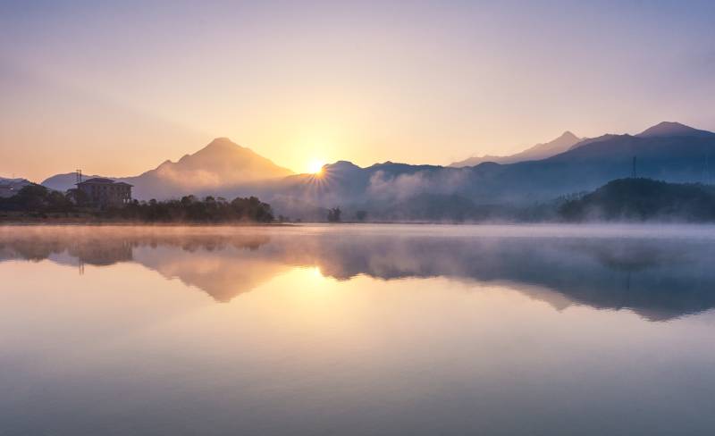 湖面日出晨雾及倒影图片