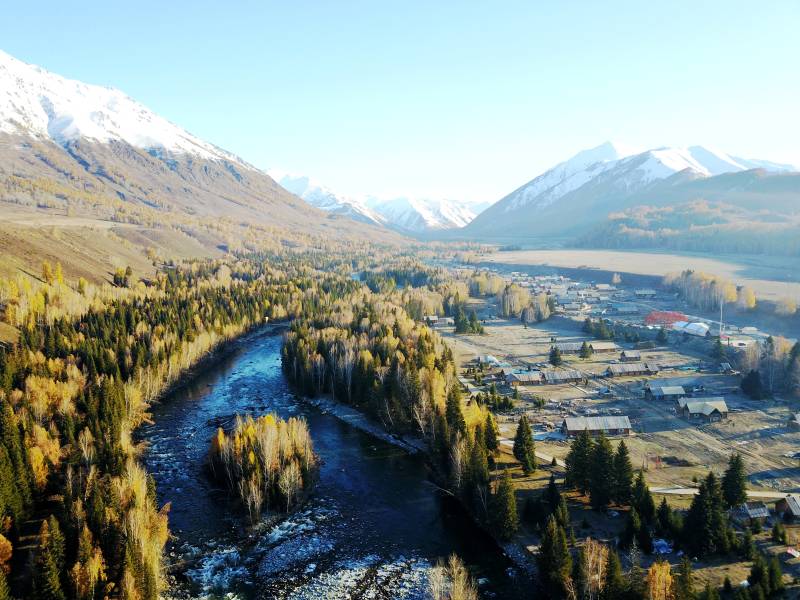 禾雪山环绕的秋日山谷图片