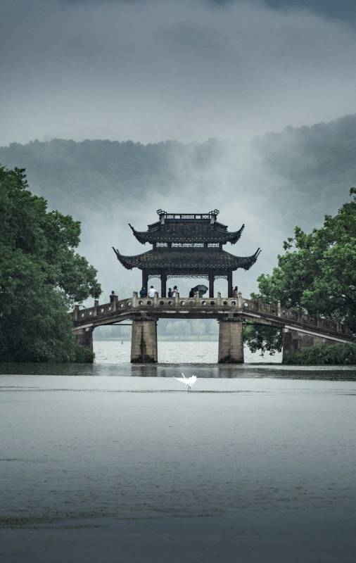 湖上古桥烟雨中图片