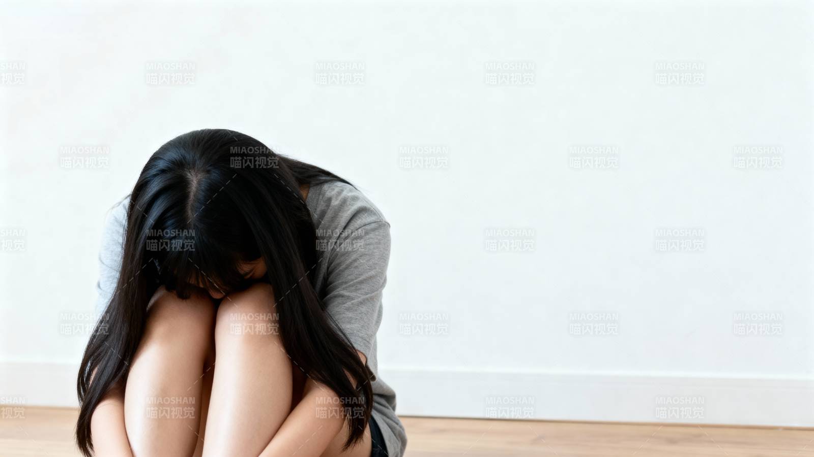 低头蜷缩的女子图片