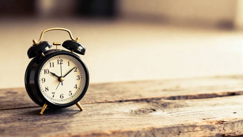 复古闹钟静置木桌图片