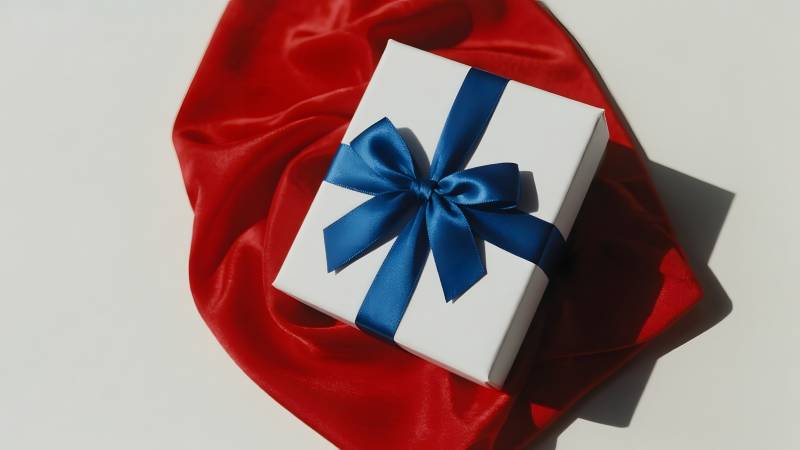 红绸上的蓝丝带礼盒图片