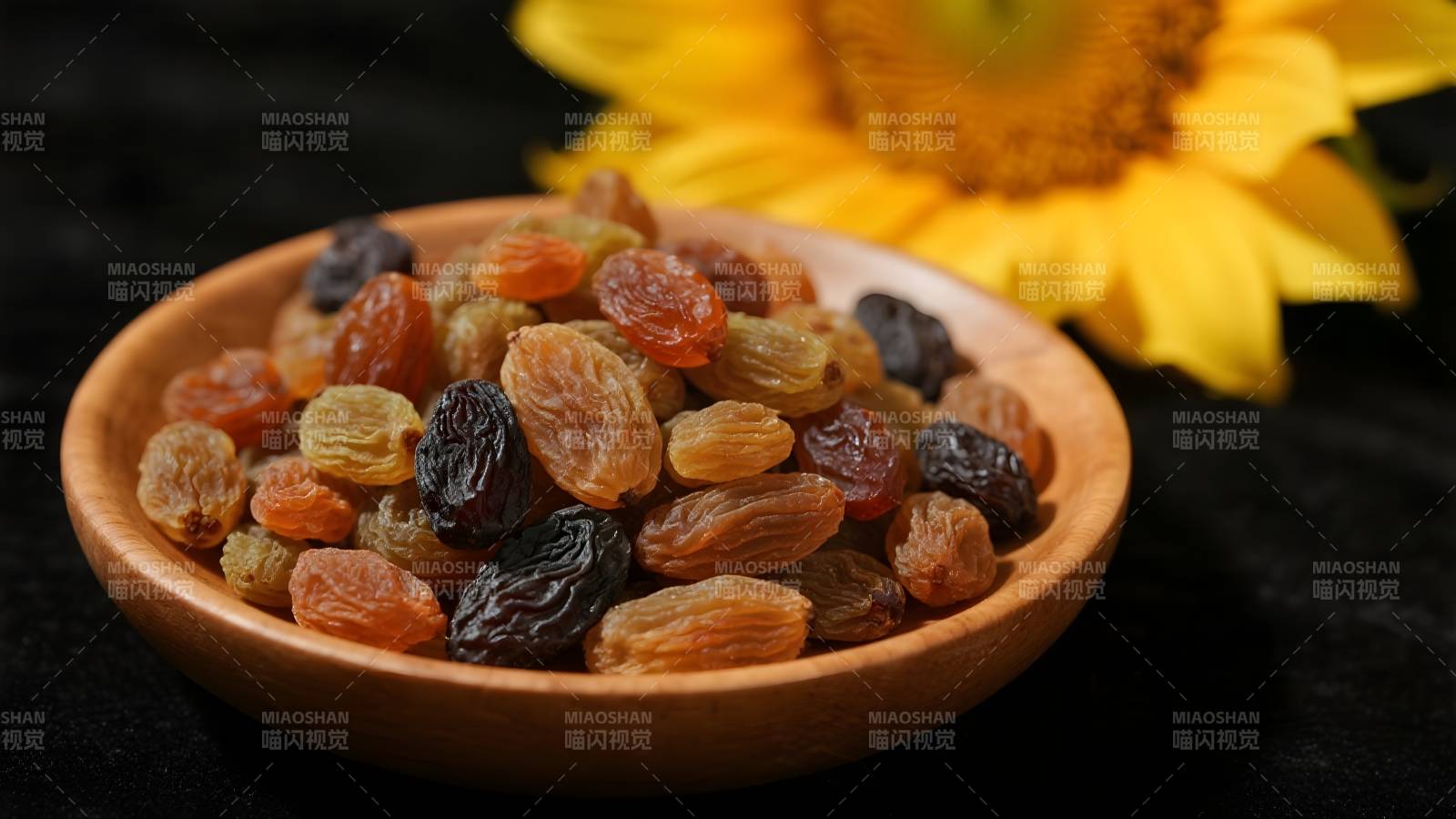 木碗葡萄干与向日葵图片