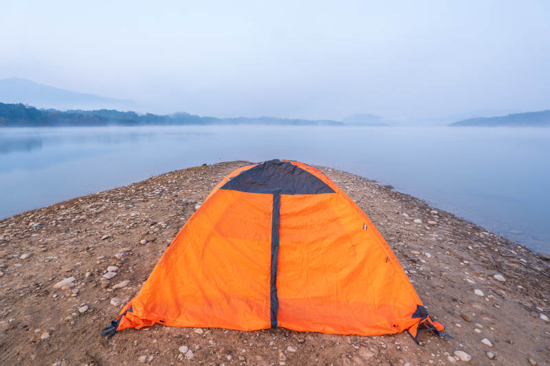 湖畔橙色帐篷露营图片