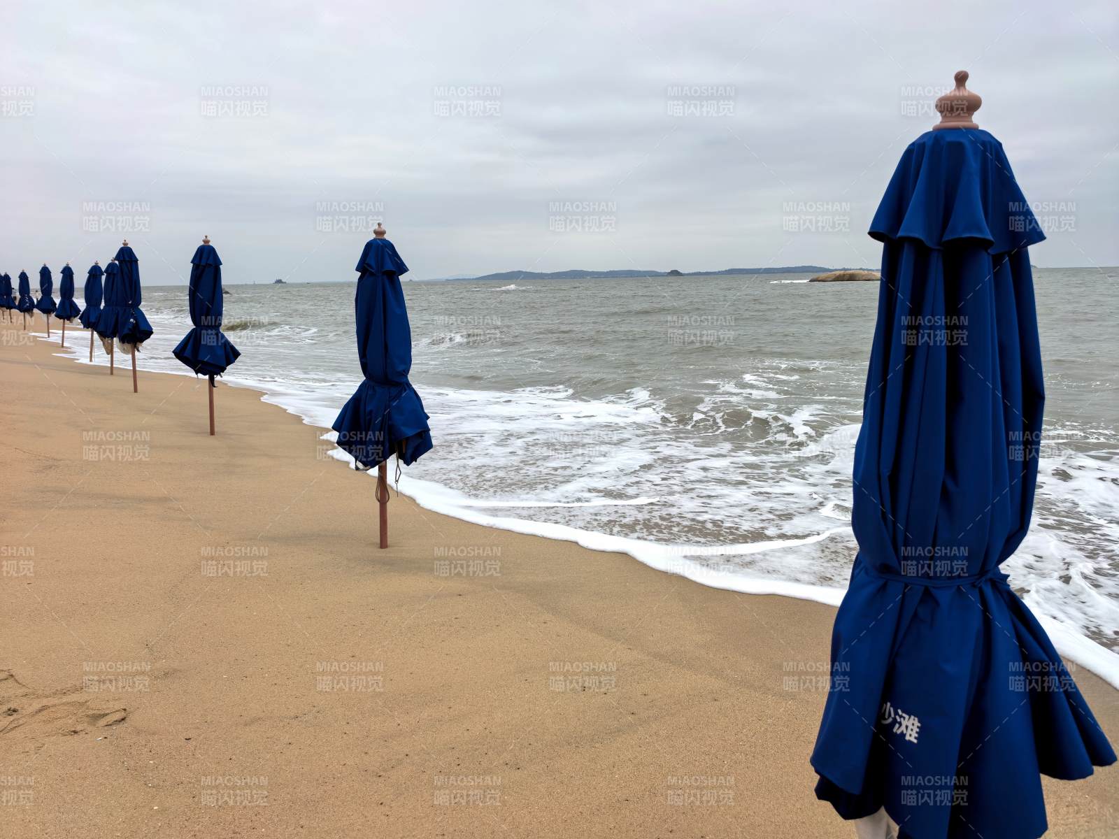 厦门海滩上的蓝色遮阳伞图片