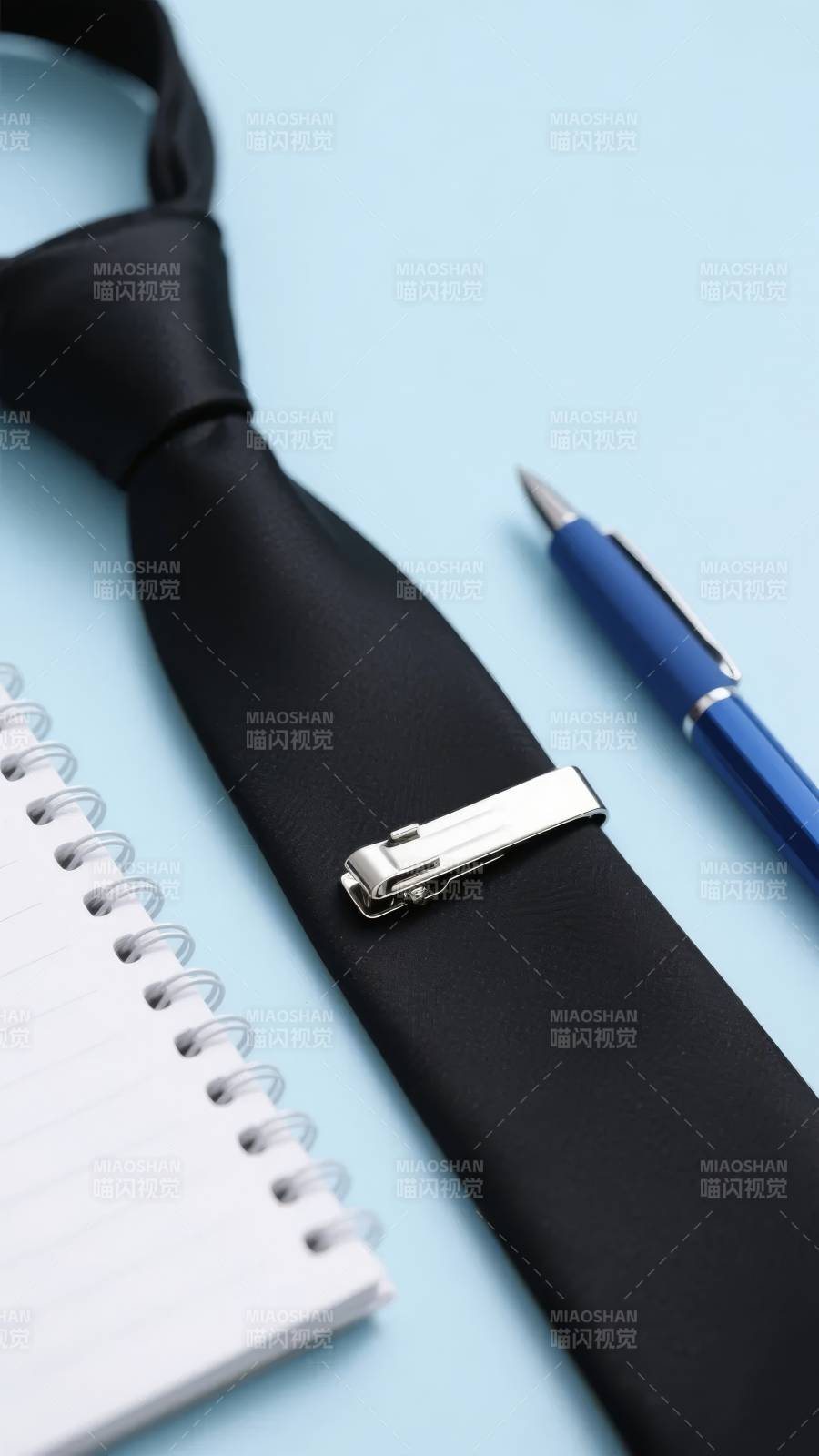 黑色领带与银色夹子、蓝色笔和笔记本图片