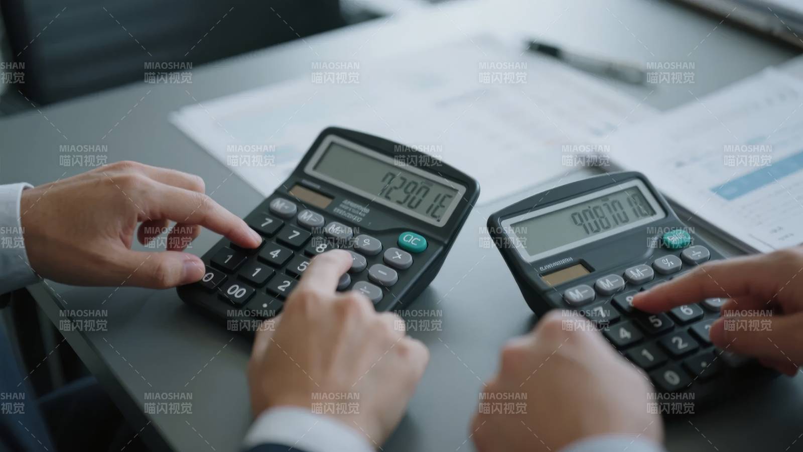 两人使用计算器进行财务计算图片