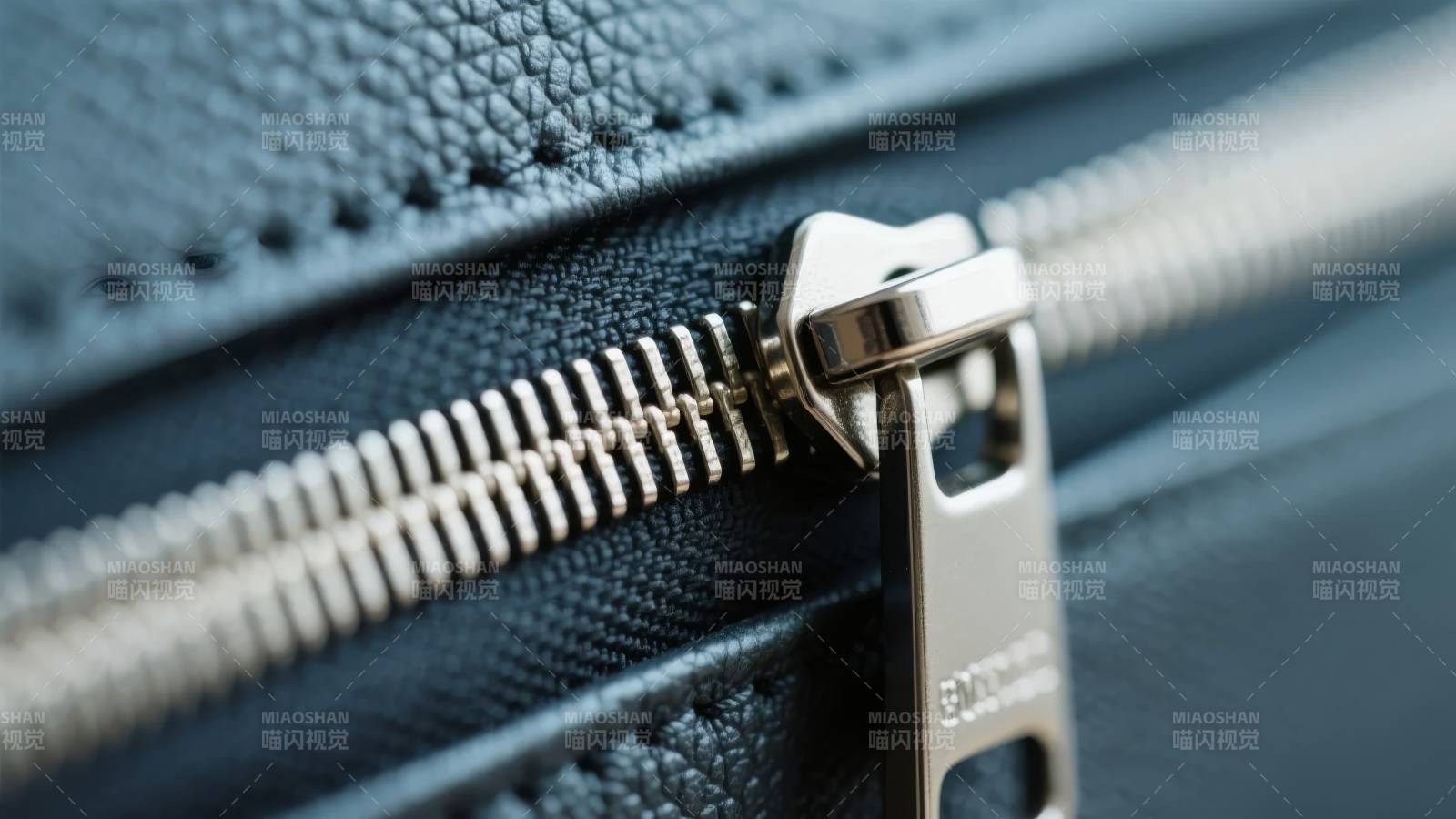 黑色皮革上的金属拉链特写图片