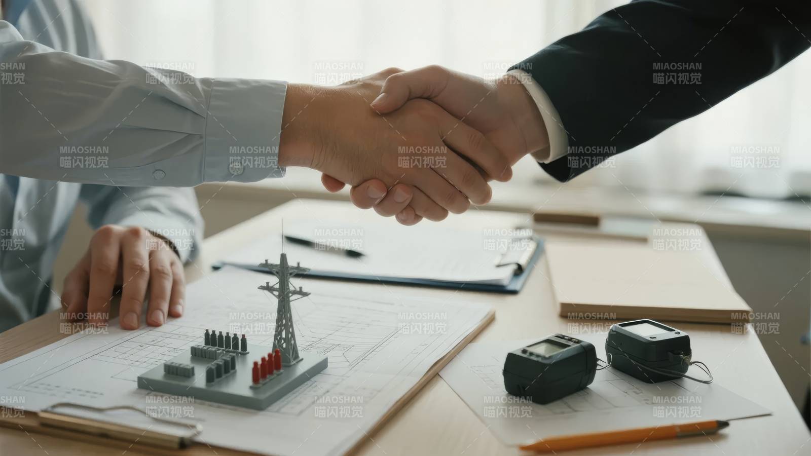 商务合作握手，桌上模型与工具图片