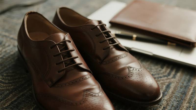 棕色皮鞋静置地毯图片