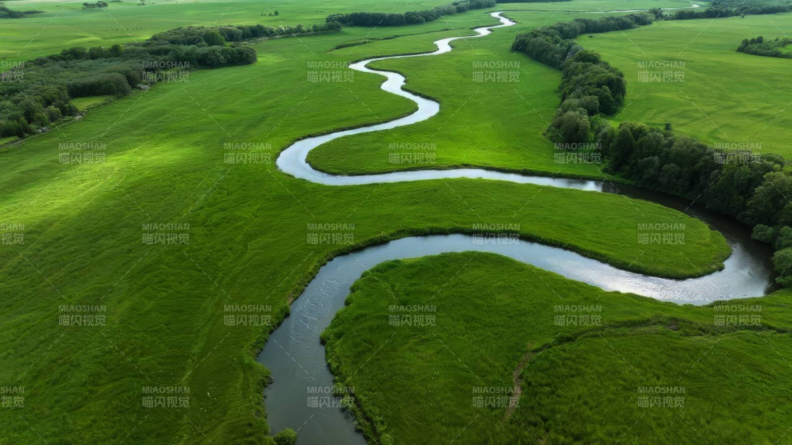 蜿蜒河流绿野间图片