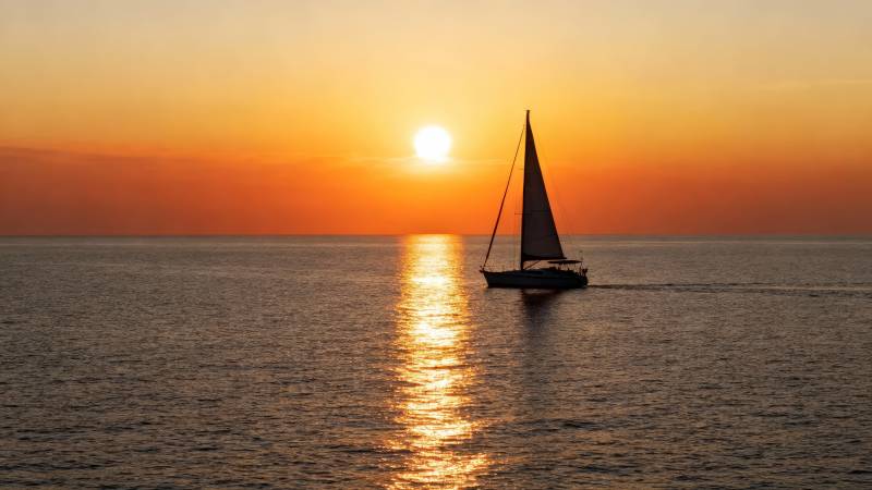 夕阳下的帆船剪影图片