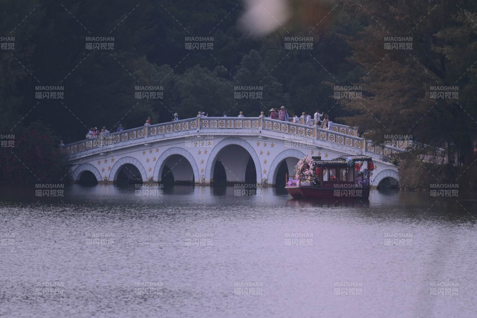 桥上人影与湖中船行图片