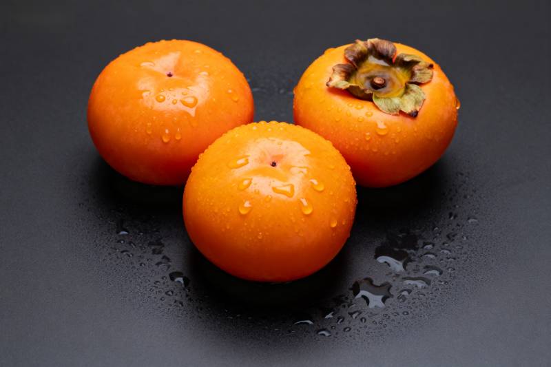 三颗柿子带水珠图片