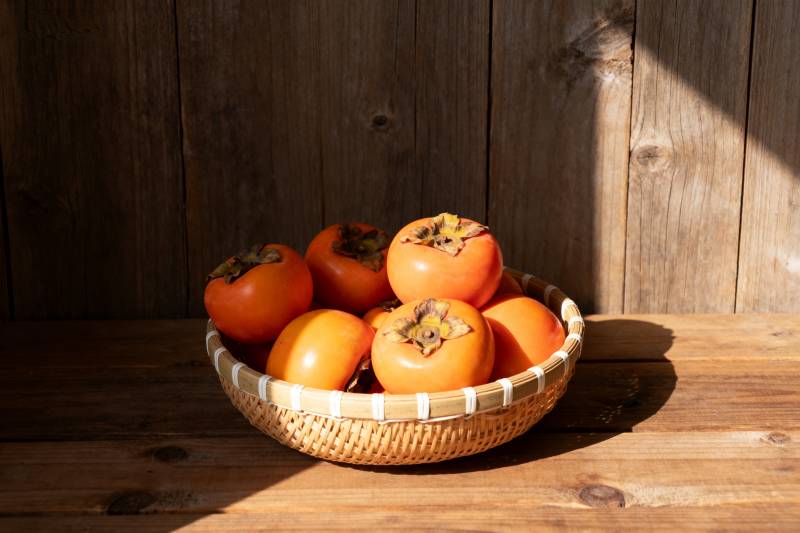 篮中柿子迎阳光图片