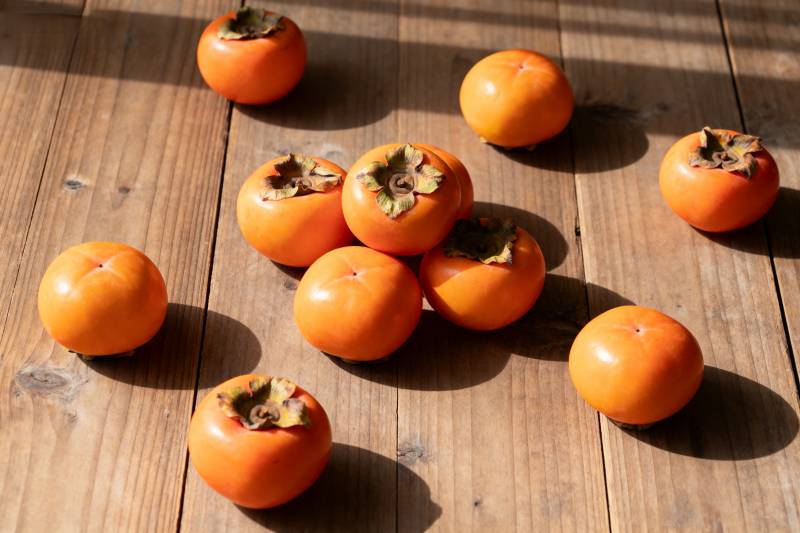 柿子静置于木桌图片