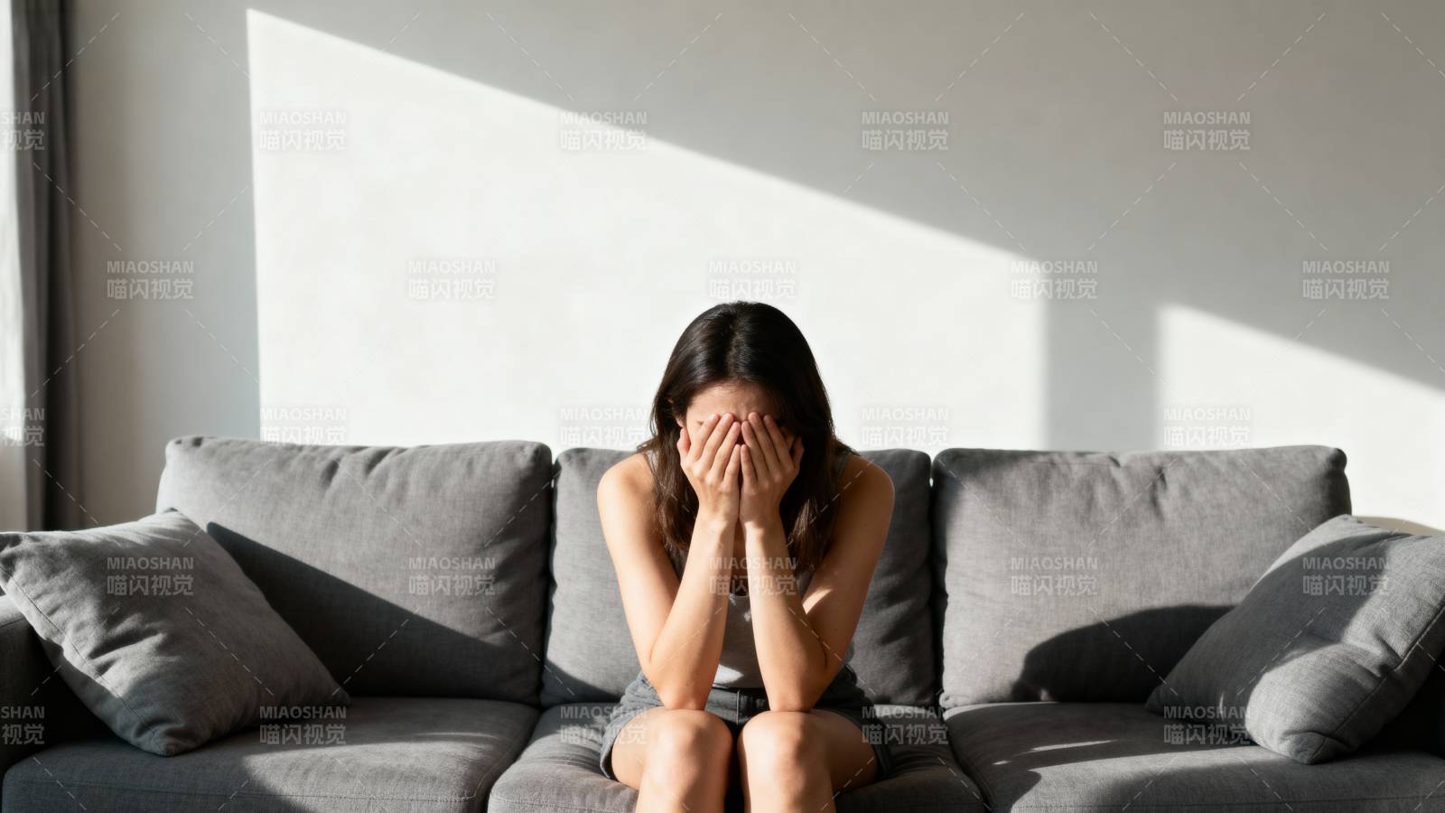 女子掩面坐在沙发上图片