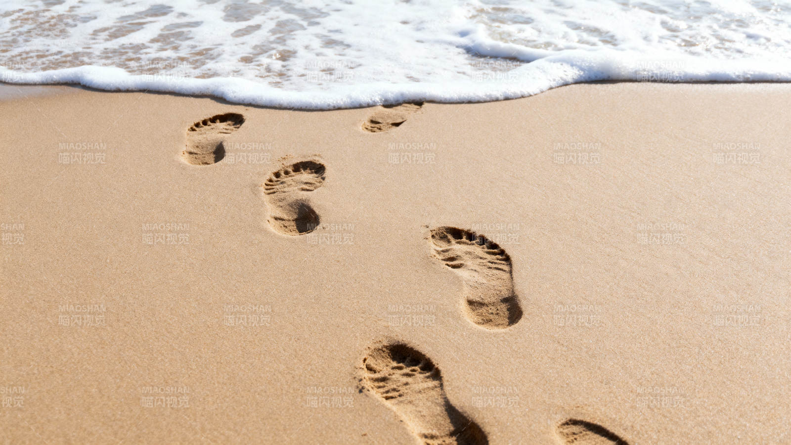 沙滩足迹迎海浪图片