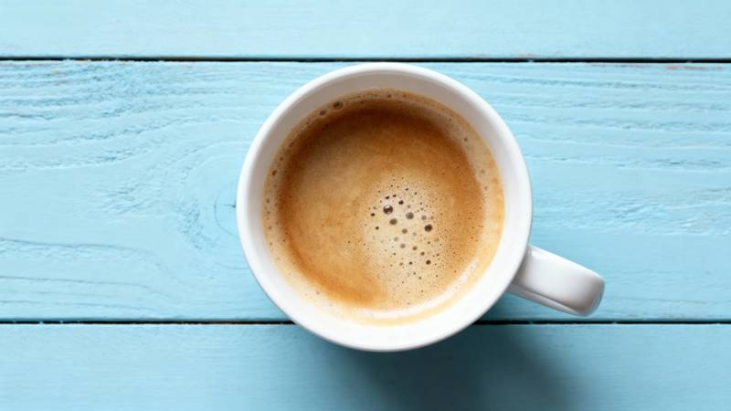 咖啡杯置于蓝木桌图片