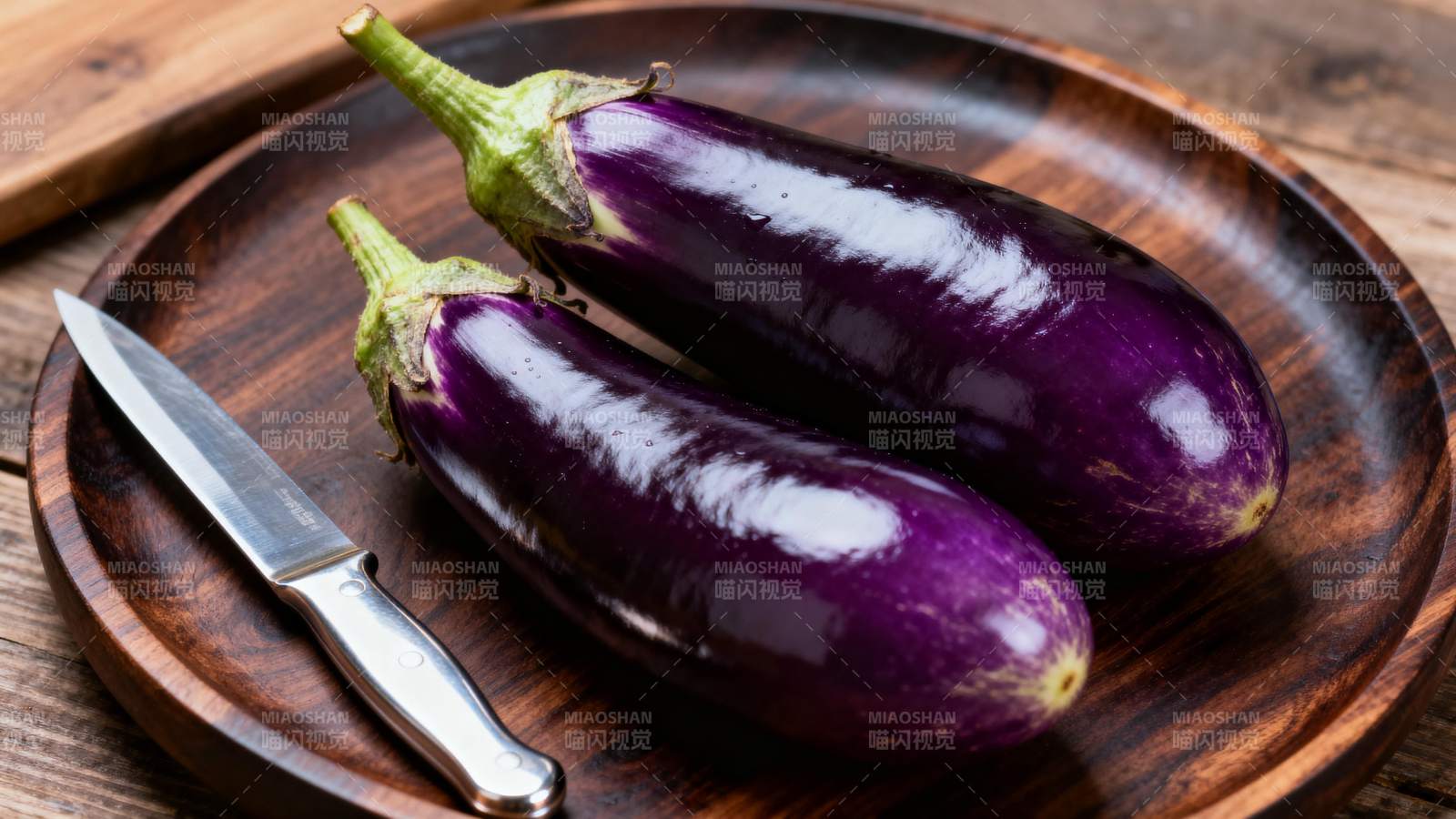 紫茄静置木盘旁图片