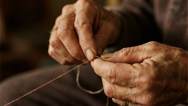老人穿针引线图片