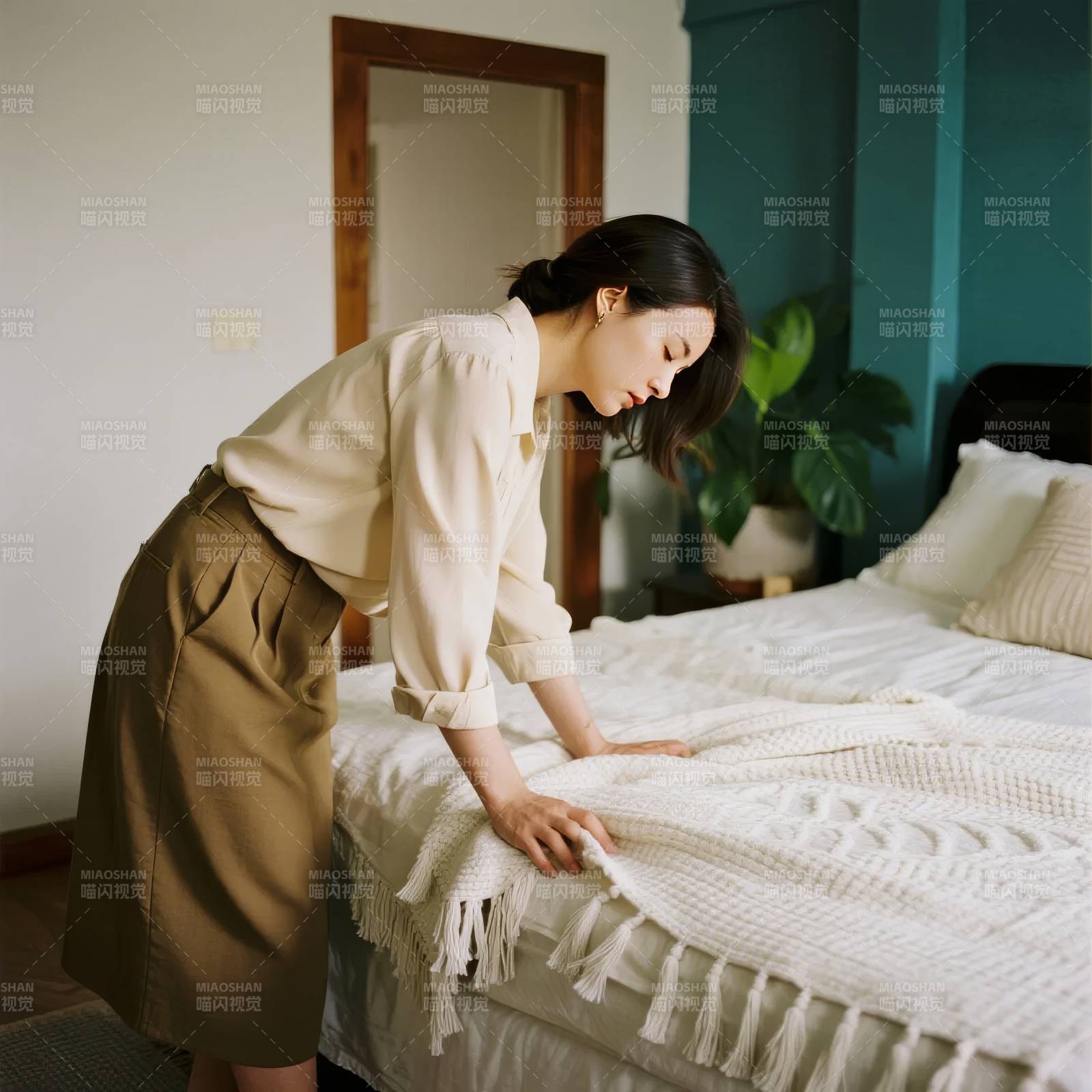 整理床铺的女子图片