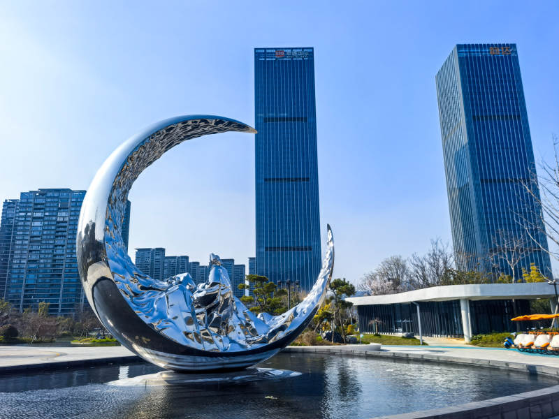 桐庐未来湖公园月牙雕塑映高楼图片