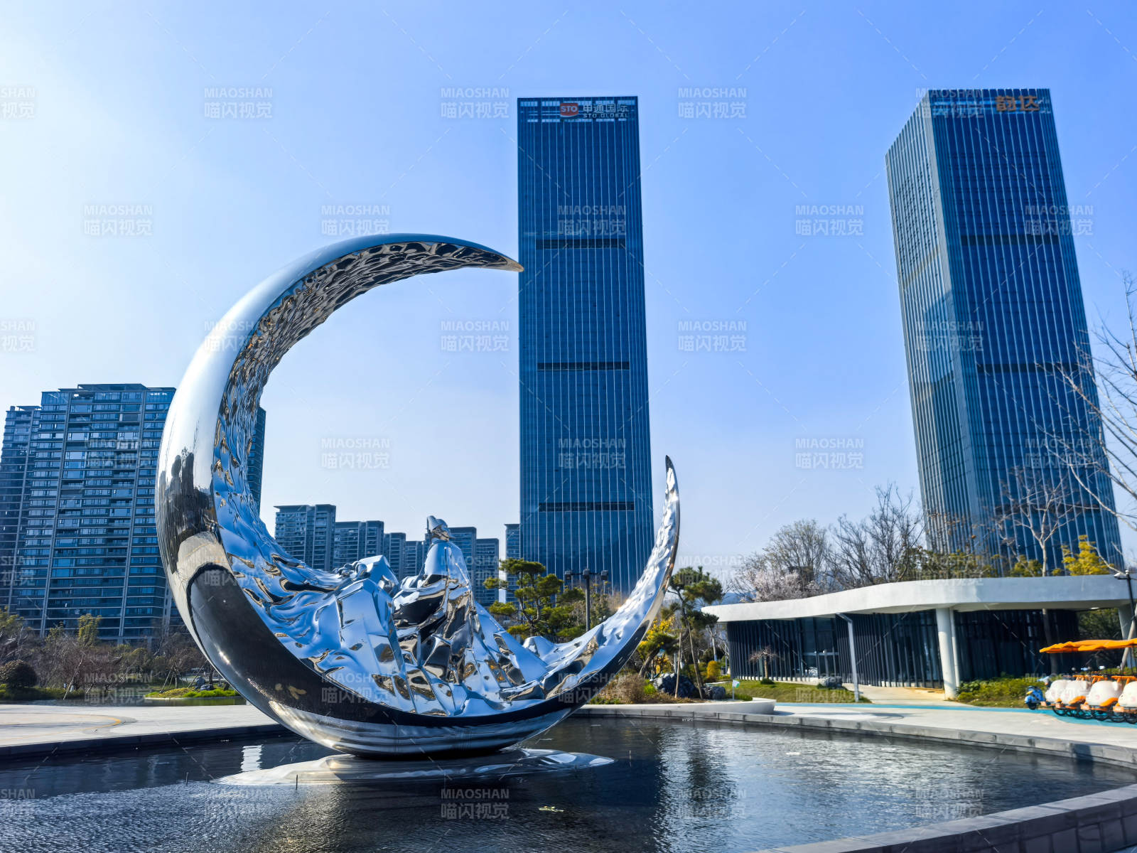 桐庐未来湖公园月牙雕塑映高楼图片