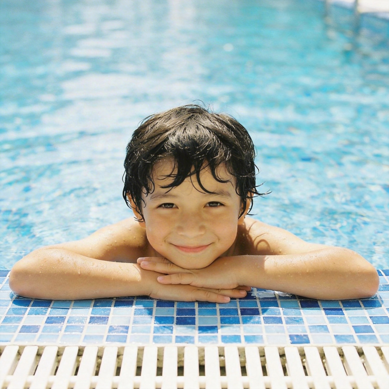 泳池中的微笑男孩图片