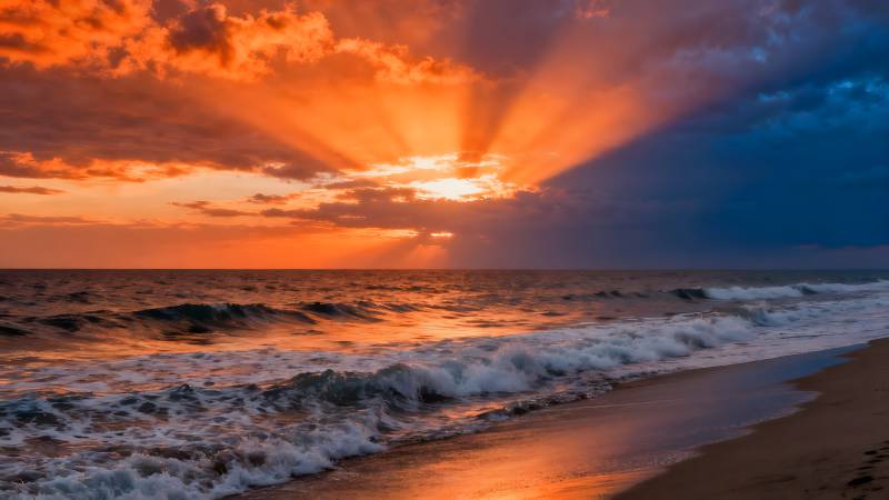 夕阳海浪映沙滩图片