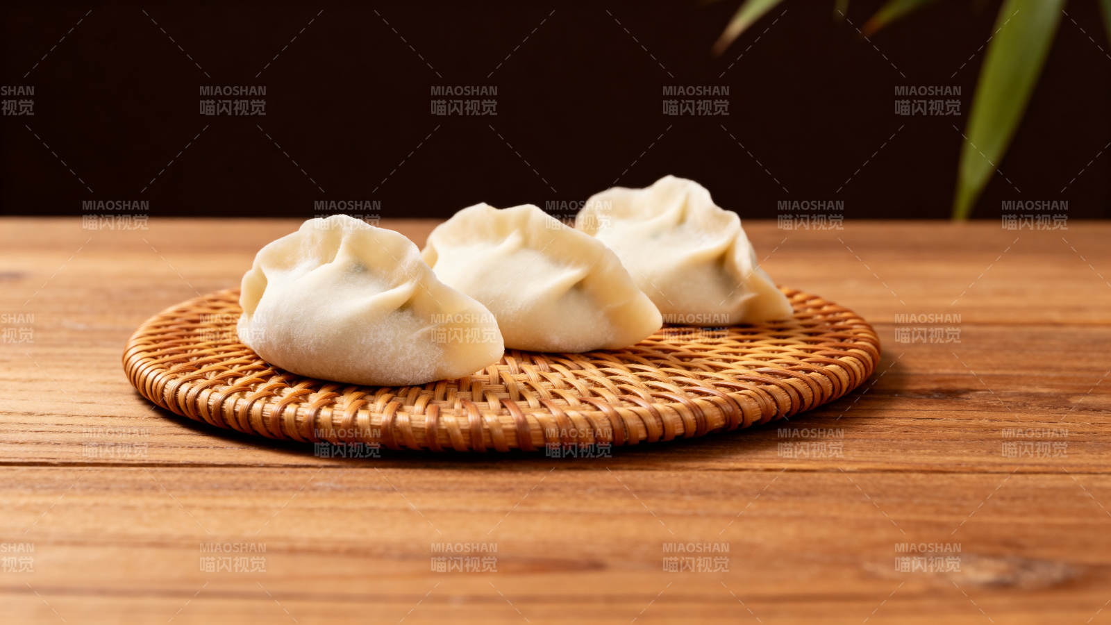 三只蒸饺静置竹垫图片