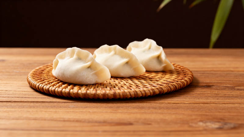 三只蒸饺静置竹垫图片