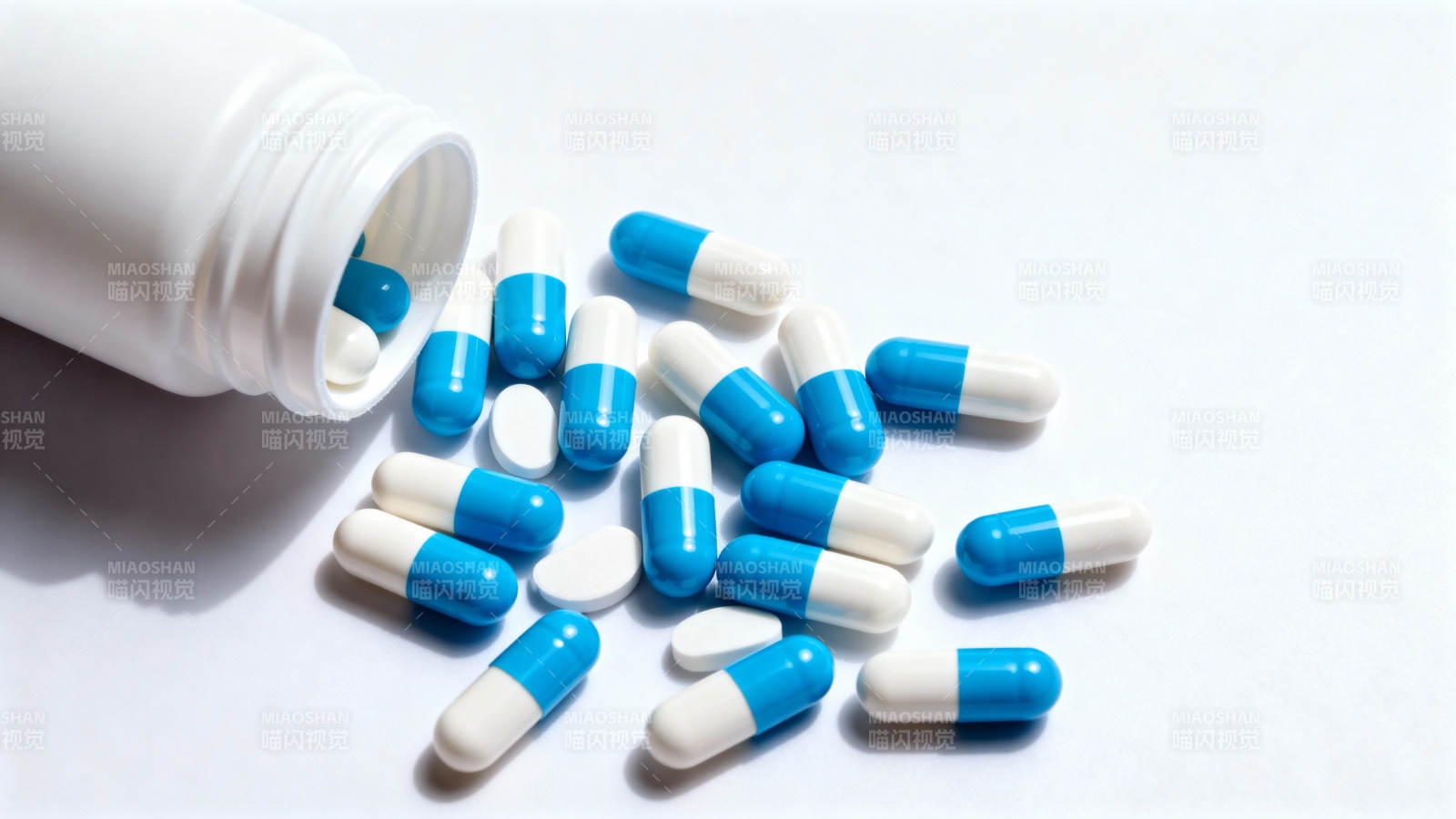 蓝白胶囊散落瓶旁图片