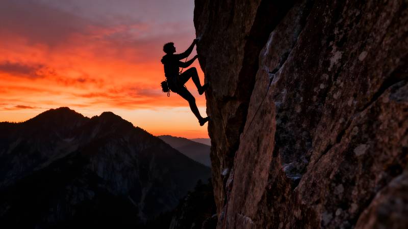 日落攀岩剪影图片