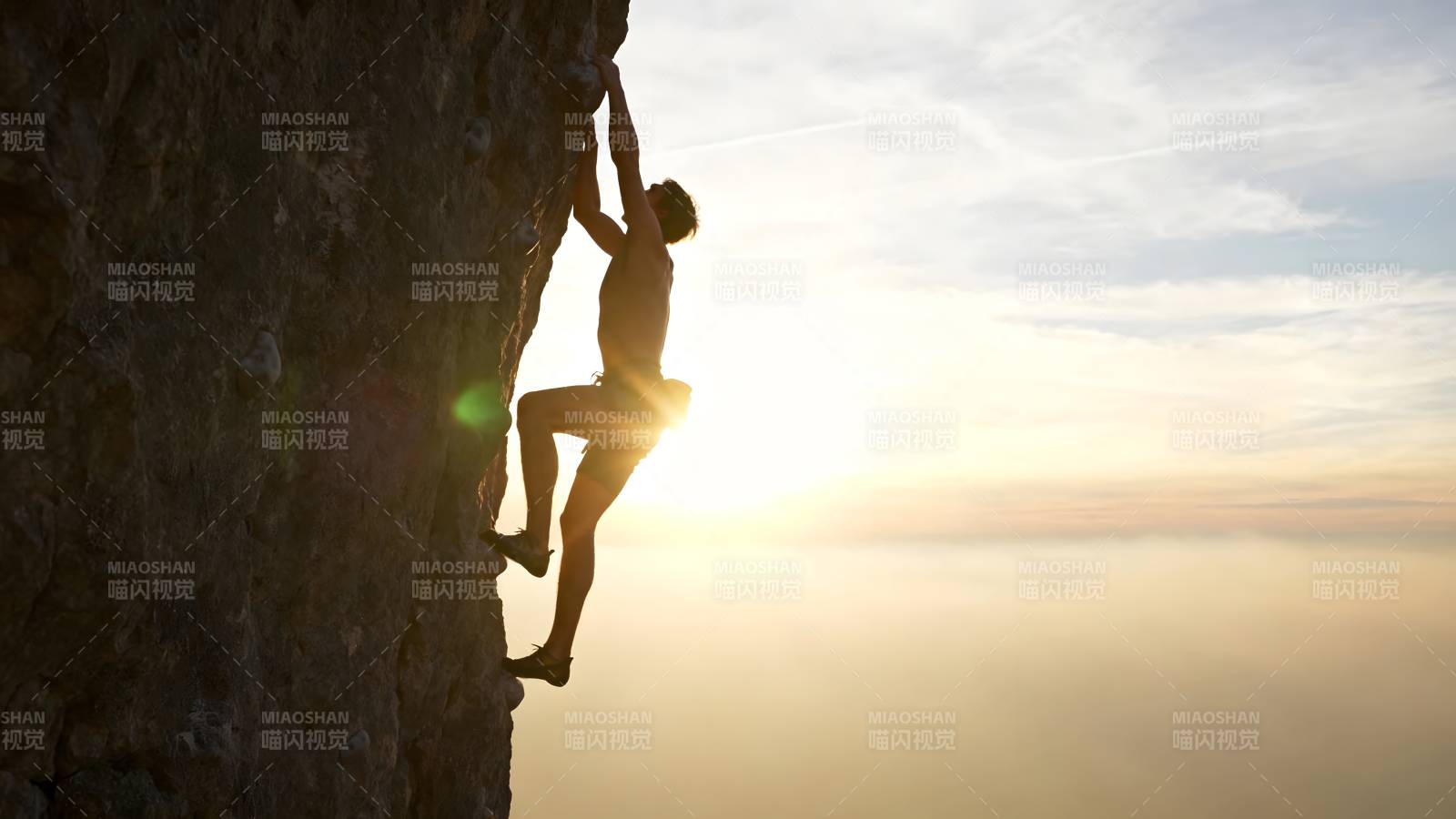 攀岩者逆光登顶图片