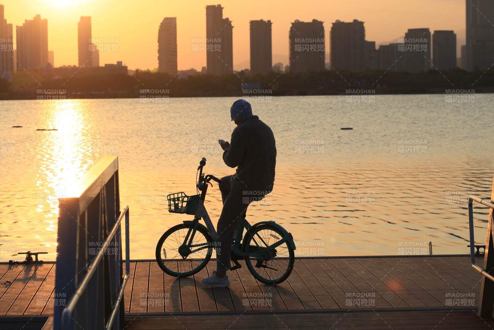湖畔骑行剪影图片