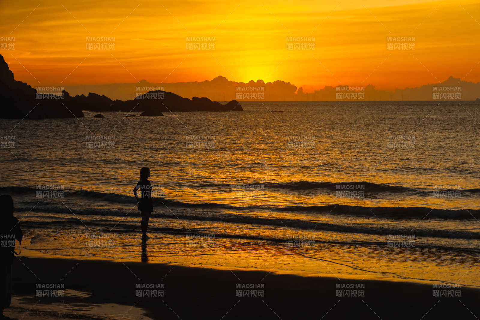 夕阳下的海滩剪影图片