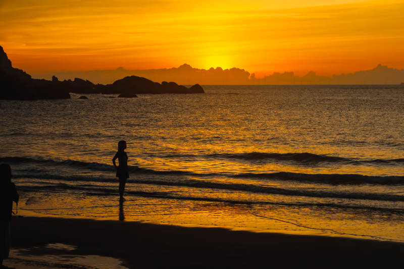 夕阳下的海滩剪影图片