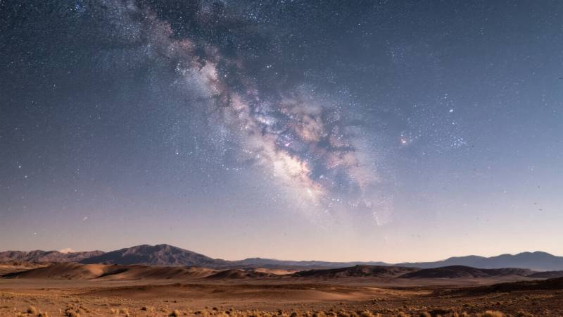 银河横跨荒漠夜空图片