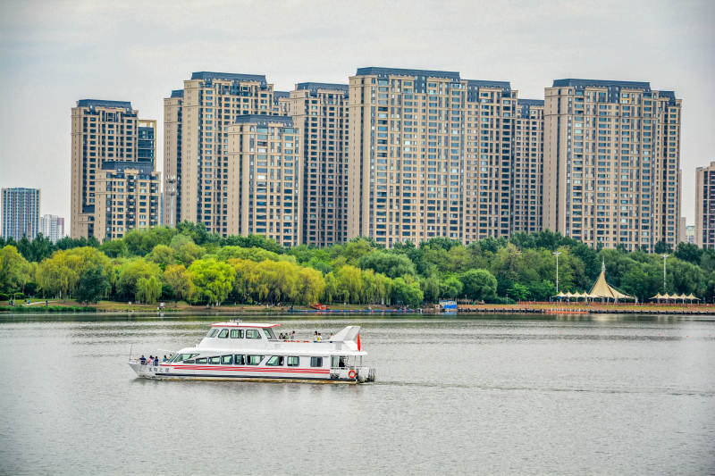 湖畔住宅高楼河景房与游船图片