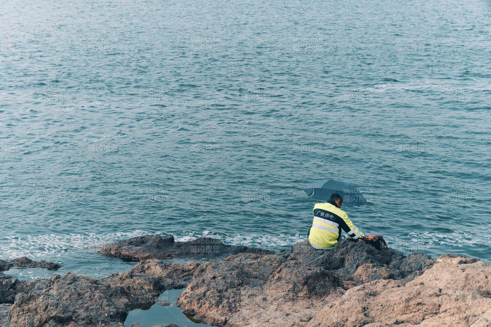 海边静坐 伞下独影图片