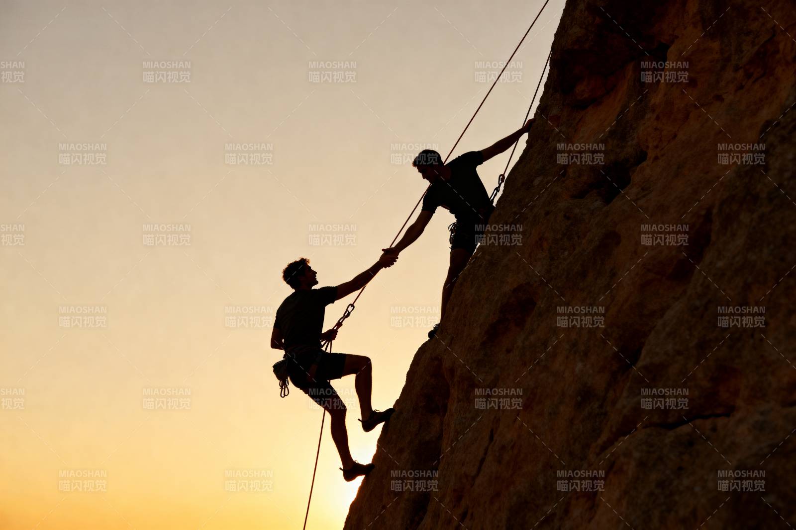 攀岩者携手登顶图片