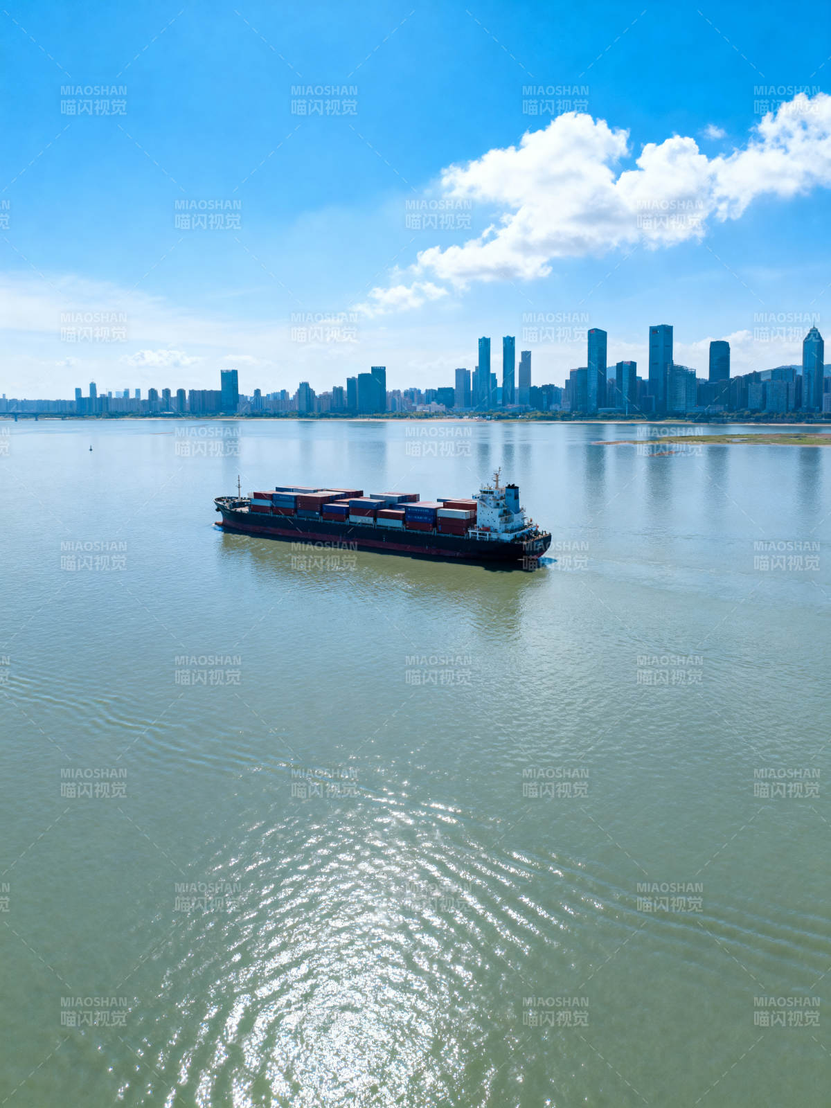 货轮驶向城市天际线图片